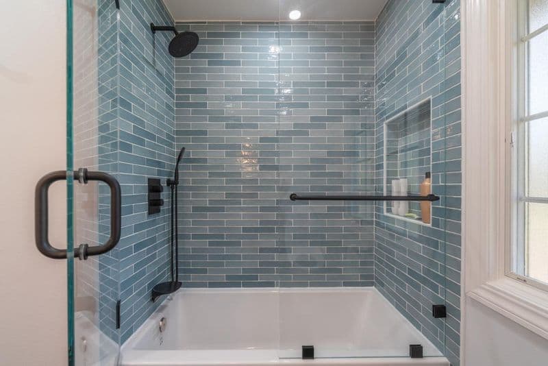 bathroom: blue glazed subway tile tub shower combo with glazed ceramic subway tile and frameless glass enclosure, by ASL Remodeling.