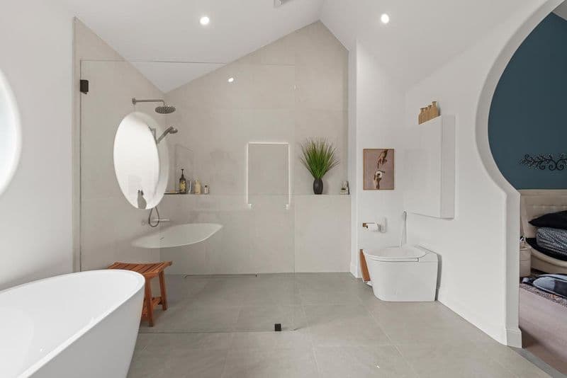 primary bathroom after: open walk in shower with rain head with large format porcelain tile and white acrylic freestanding tub, by ASL Remodeling, Pacifica.