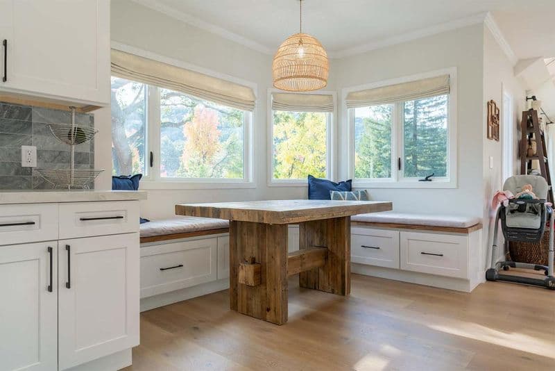 Vista Del Mar home remodel featuring completed kitchen with custom white cabinetry, wood island, and breakfast nook with natural lighting by ASL Remodeling in Los Gatos