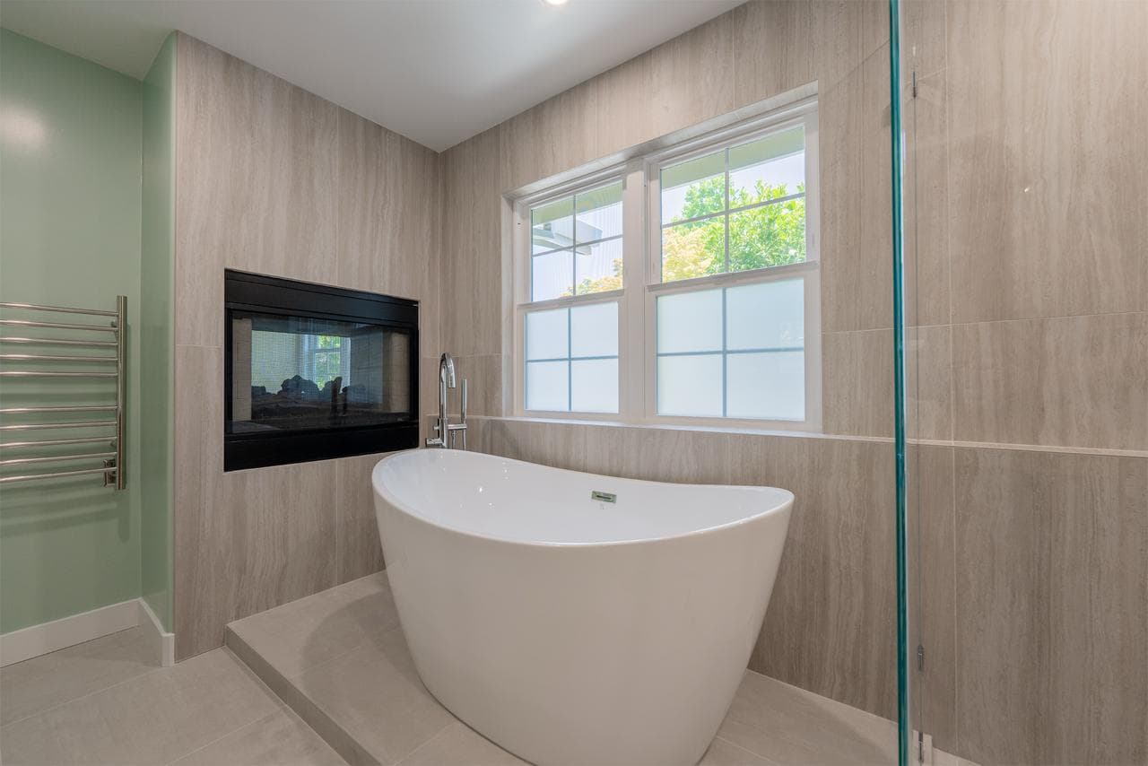 Freestanding soaking tub detail in Monte Sereno master suite with chrome floor-mounted filler, radiant heated tile floors, and spa-inspired ambiance