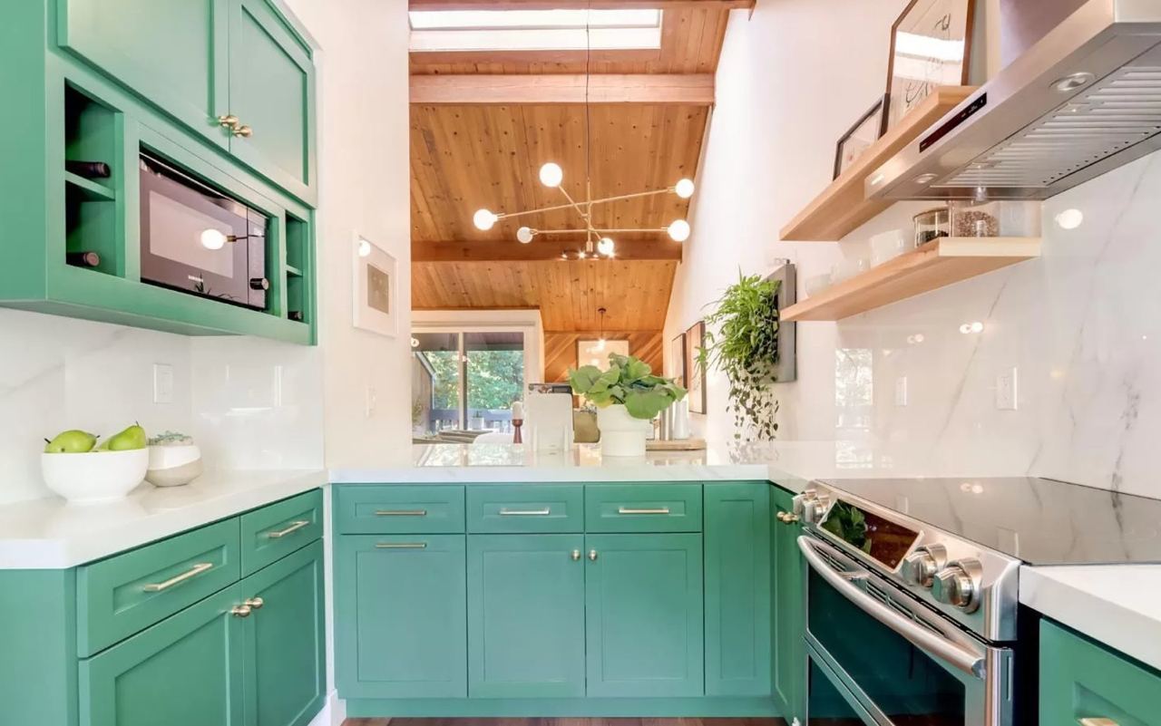 Kitchen contractors design custom cabinetry with wood ceiling and skylight in Los Gatos home featuring green cabinets