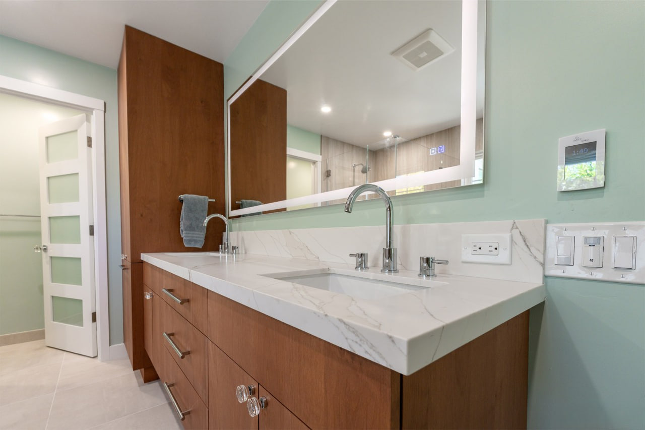 Modern bathroom design featuring beautiful floating vanity in rich wood finish with white quartz countertop and classic white subway tile