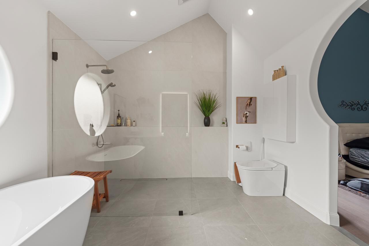 primary bathroom after: open walk in shower with rain head with large format porcelain tile and white acrylic freestanding tub, by ASL Remodeling, Pacifica.