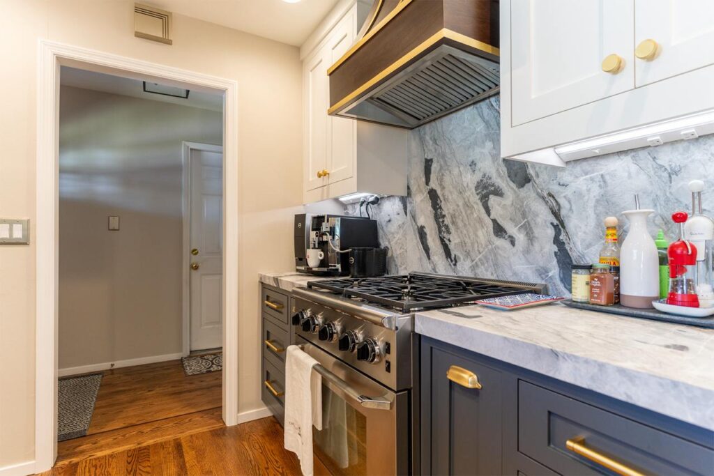 Bucher Ave kitchen in Santa Clara with bookmatched marble countertops, full-height backsplash slabs, custom inset cabinetry, and soft brass hardware