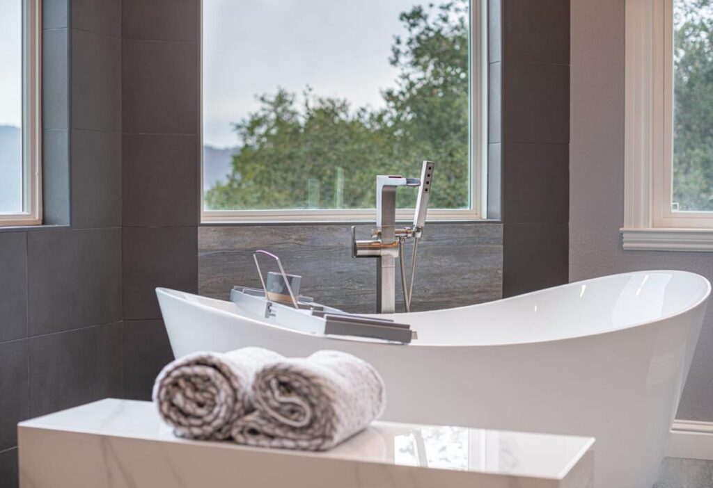 Knowing how to choose a remodeling contractor ensures stunning results like this luxury bathroom with freestanding tub and breathtaking mountain views