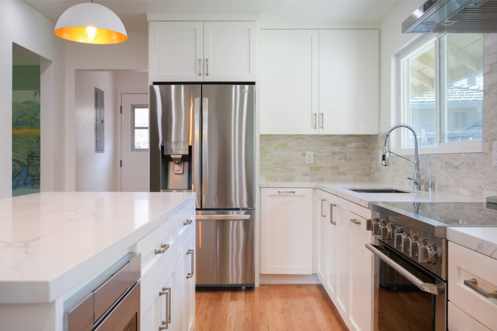 Pull-out pantry systems installed in San Francisco kitchen with white shaker cabinets, LED under-cabinet lighting, and stainless steel appliances by ASL Remodeling