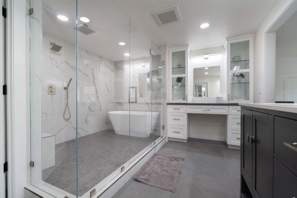 Professional remodeling by bathroom contractors in San Jose delivering sleek tub-shower combination with frameless glass enclosure and white tile