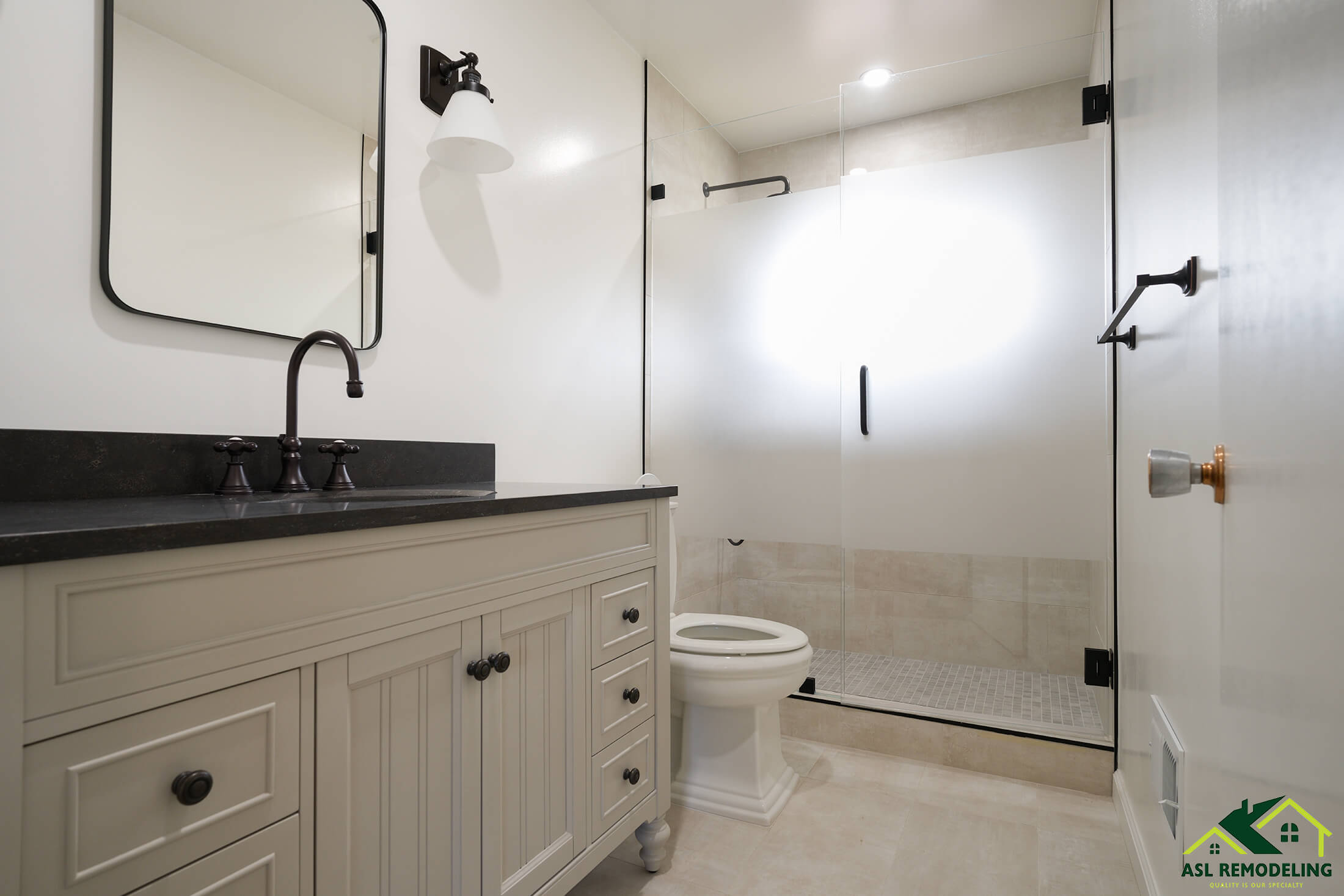 Transitional bathroom remodel in Los Gatos featuring a frameless glass shower, black countertop with vessel sink, light gray vanity, and matte black fixtures. Renovation by ASL Remodeling.