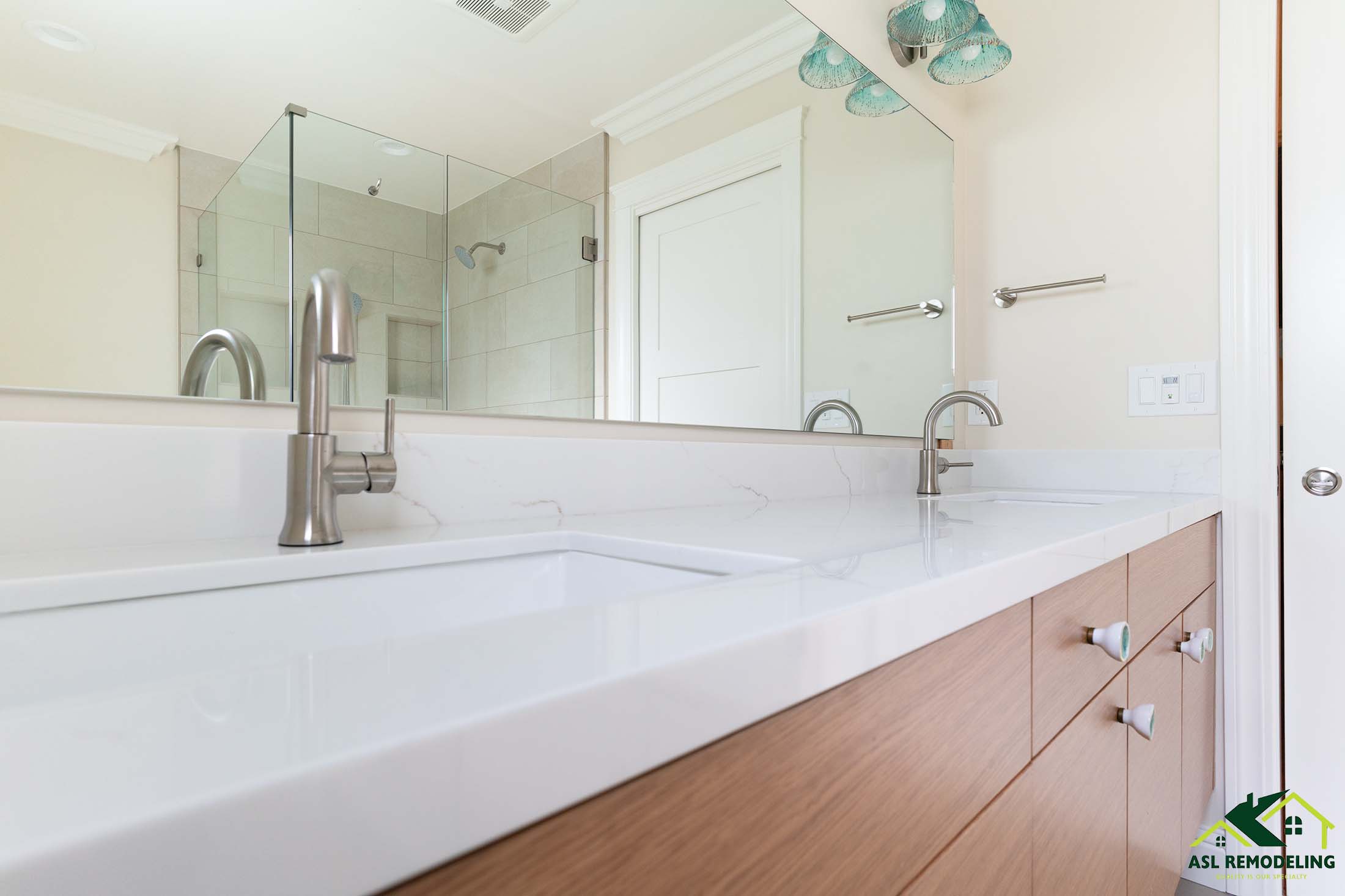 Modern bathroom remodel featuring double sink vanity with light wood cabinets, white quartz countertop, brushed nickel faucets, and frameless glass shower enclosure – San Jose bathroom renovation design.