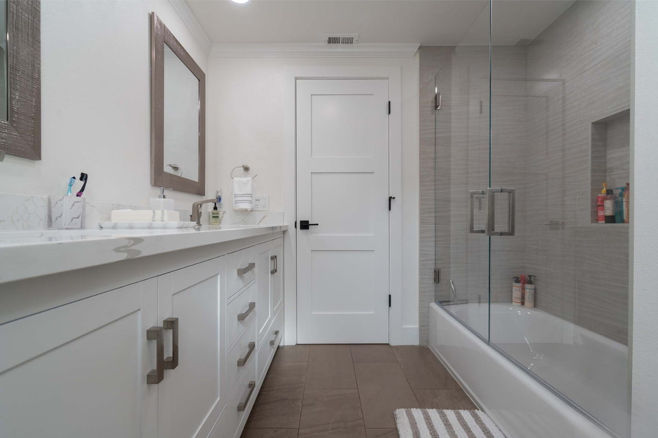 Professional bathroom remodel service in San Jose delivering bright, functional spaces with frameless glass shower and custom light wood vanity