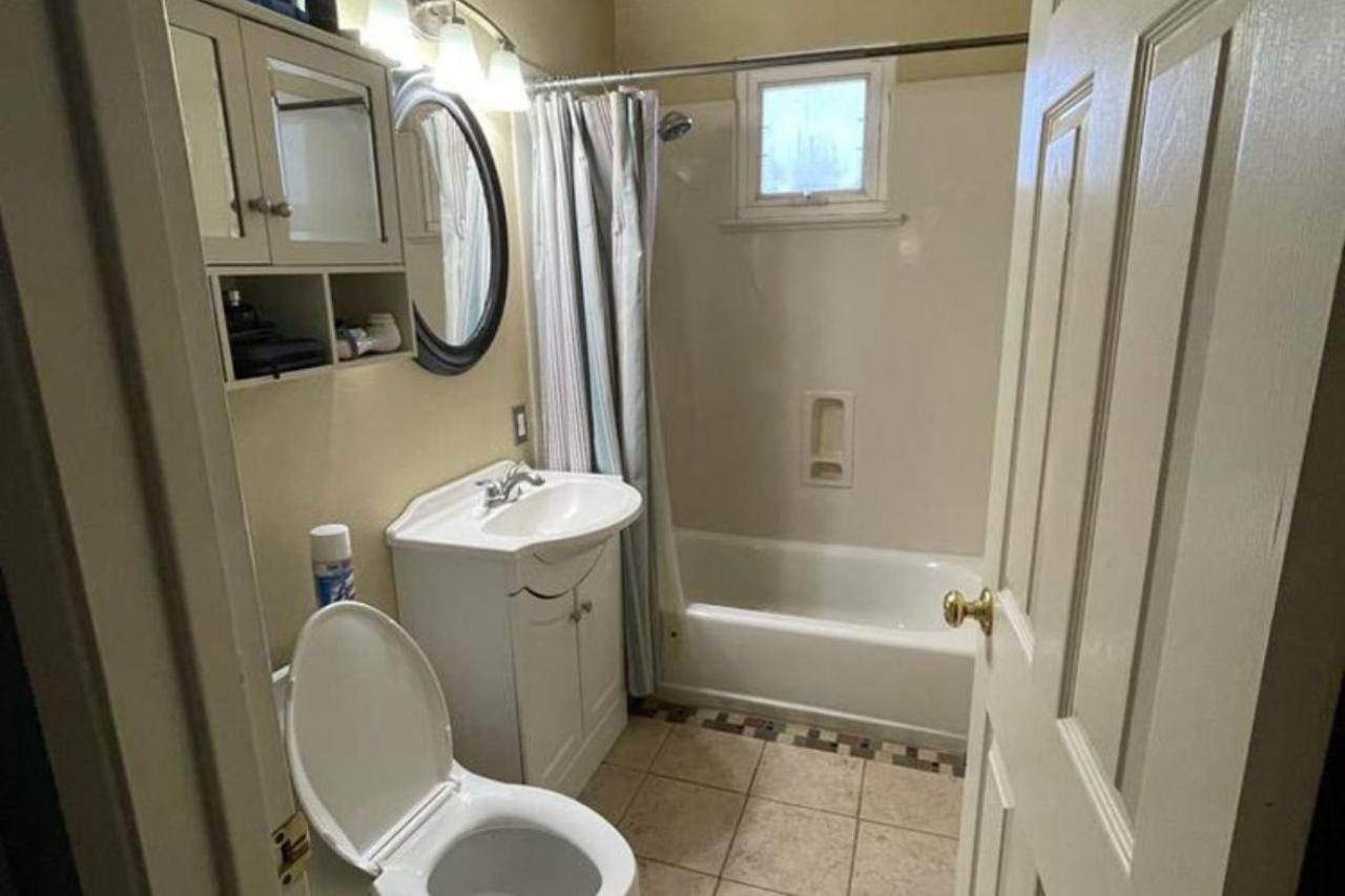 Before photo of dated bathroom with old pedestal vanity and beige tile in Santa Clara home renovation, showing original condition with shower curtain and basic fixtures prior to complete transformation