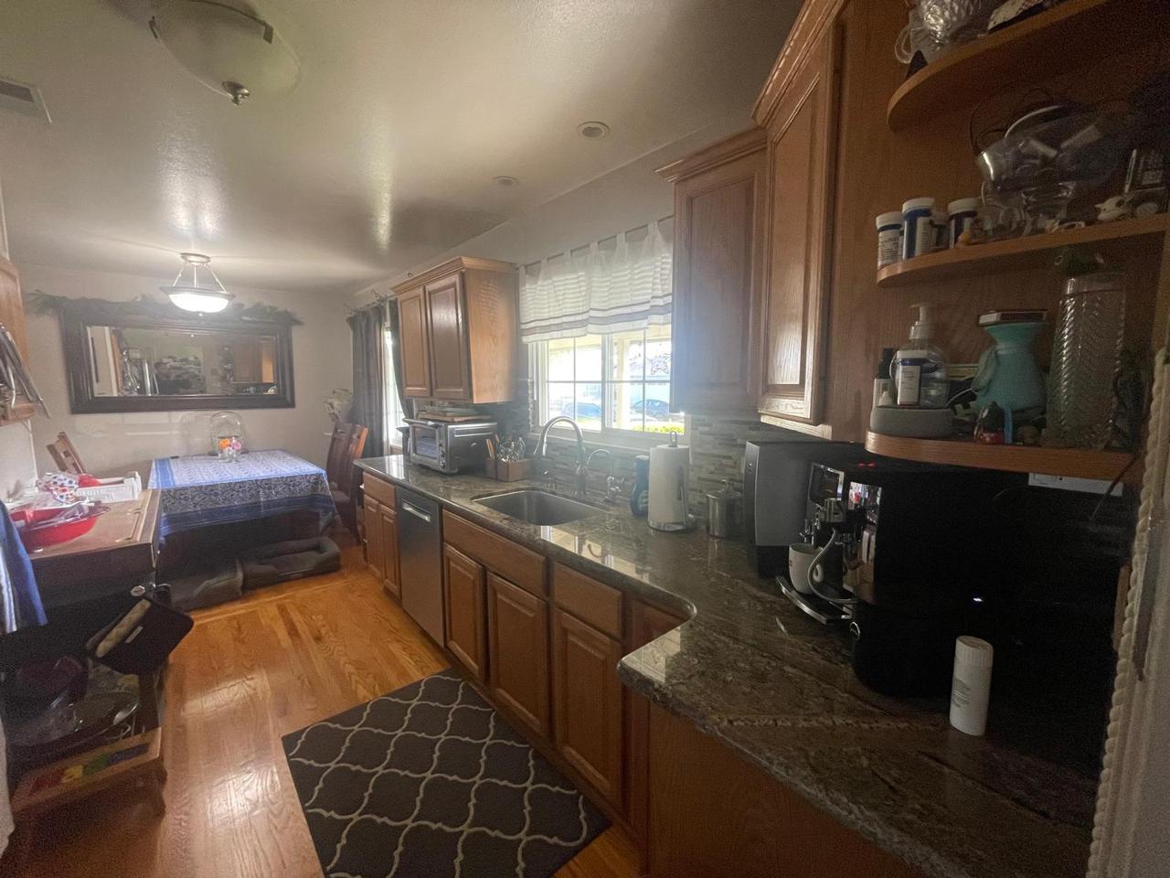 Before condition of outdated kitchen in Santa Clara home remodeling project showing old dark wood cabinets, dated countertops, worn hardwood flooring, and original layout prior to complete kitchen transformation by ASL Remodeling